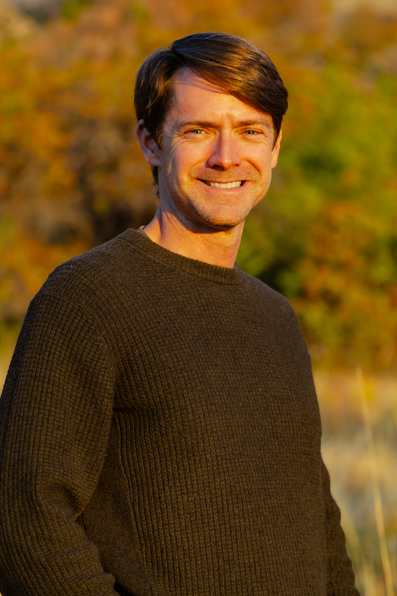 Patten Wood smiling outdoors at golden hour
